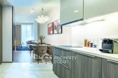Modern open-plan kitchen and living room with stylish decor and natural light.