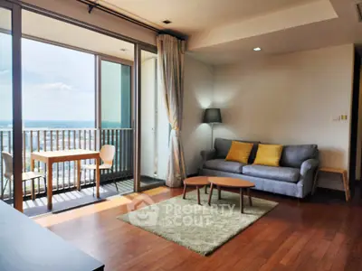 Spacious living room with balcony and stunning view, featuring modern furniture and natural light.