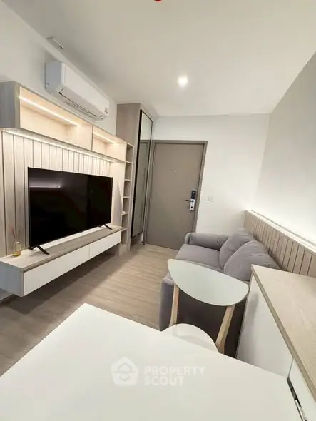 Modern living room with sleek furniture and large TV, perfect for urban living.