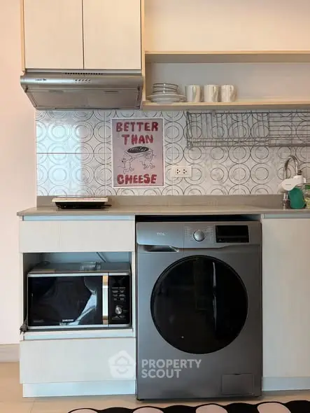 Modern kitchen with washing machine and microwave, stylish backsplash, and open shelving.