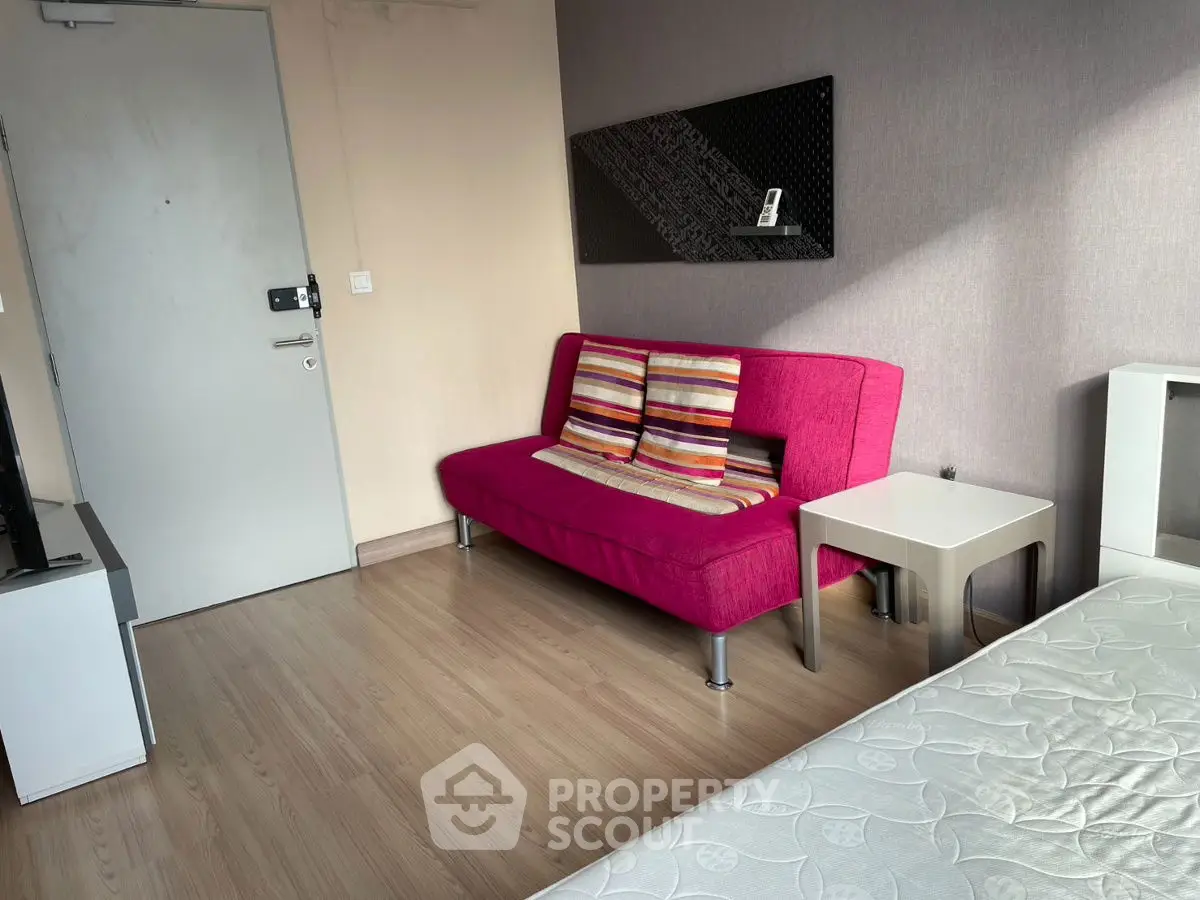 Cozy studio apartment with vibrant pink sofa and modern decor
