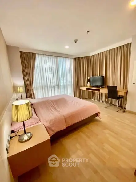 Spacious bedroom with modern decor and natural light in a stylish apartment.