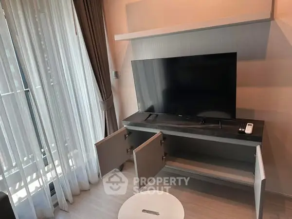 Modern living room with TV stand and large window curtains