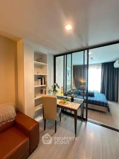 Modern studio apartment with glass partition, cozy living area, and stylish bedroom.