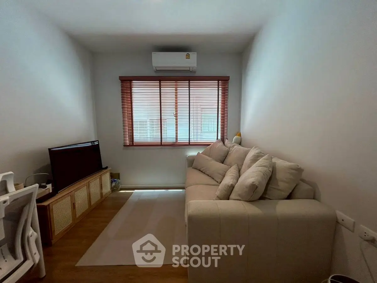 Cozy living room with modern sofa and wall-mounted air conditioner