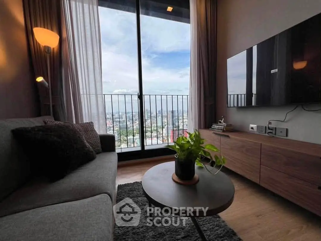 Modern living room with city view, cozy sofa, and stylish decor in high-rise apartment.