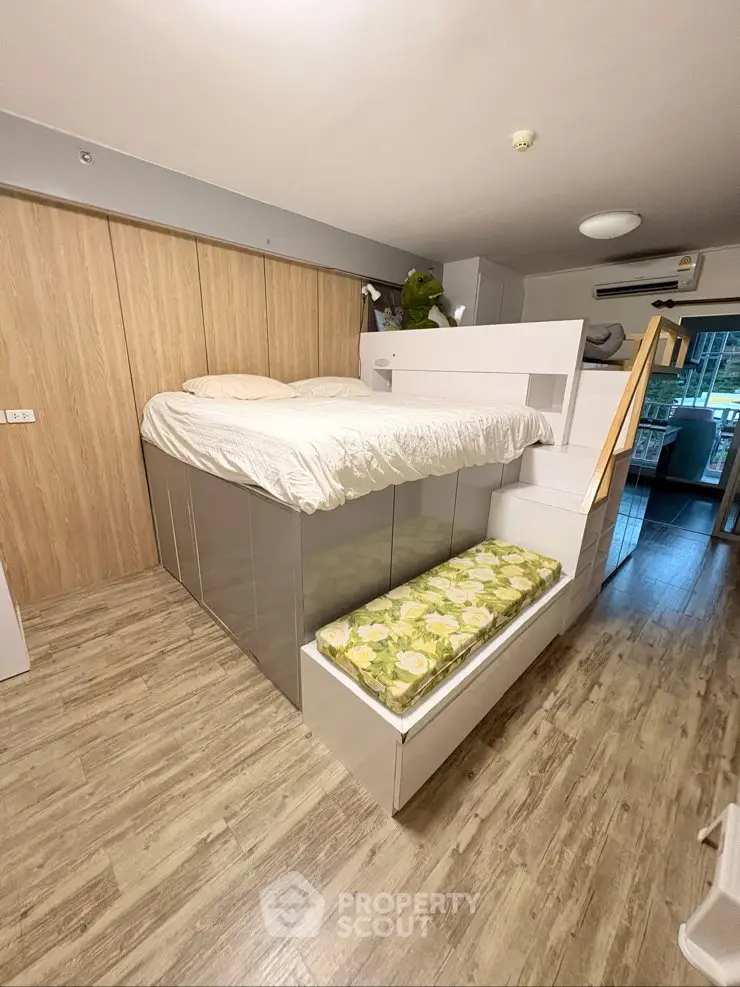 Modern studio apartment with loft bed and stylish wooden flooring