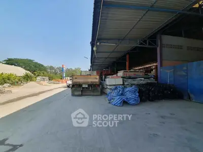 Industrial warehouse exterior with loading dock and storage materials