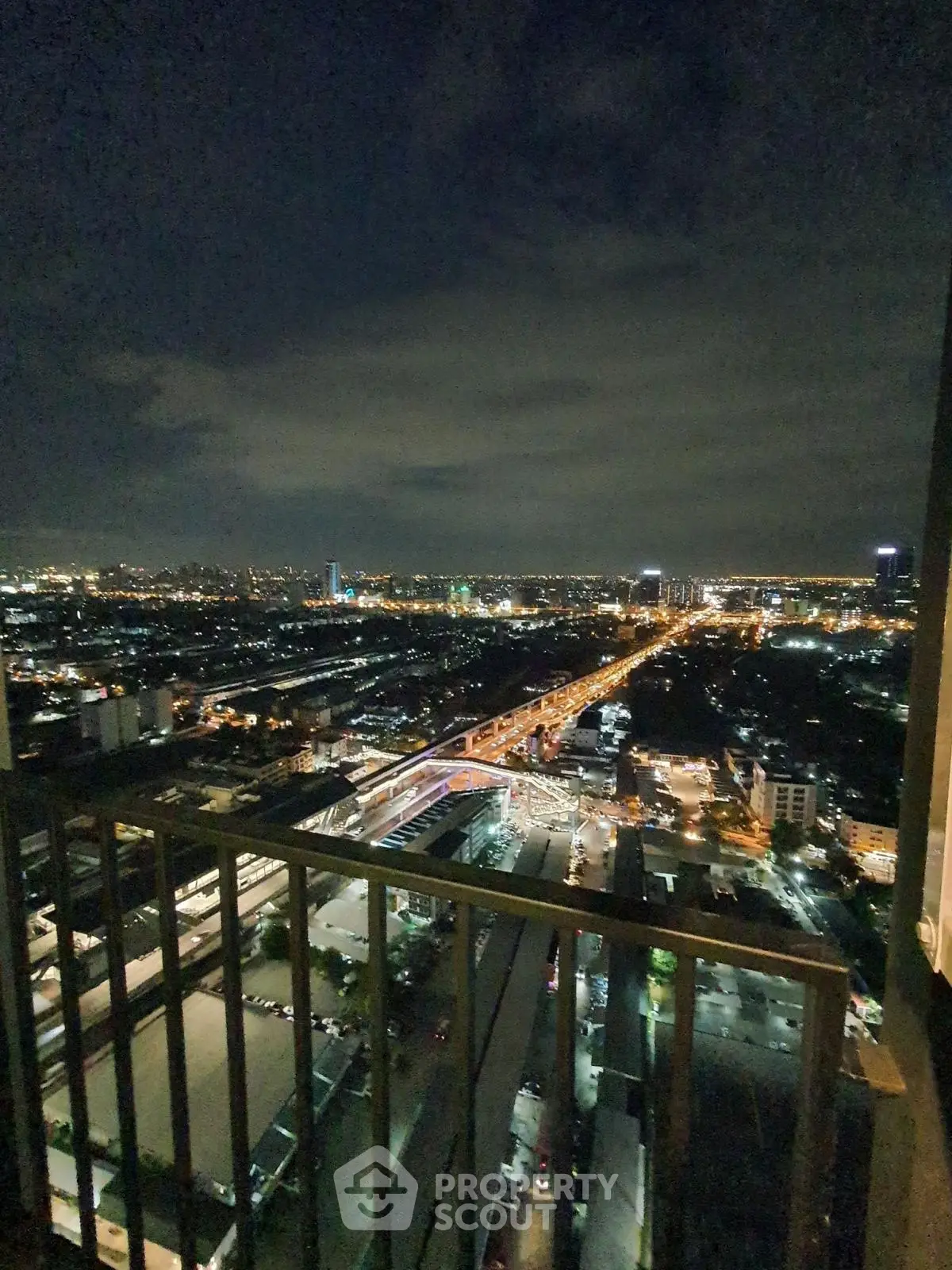 Stunning night cityscape view from a high-rise balcony, showcasing vibrant city lights and skyline.