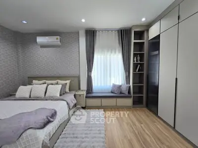 Modern bedroom with stylish decor, built-in storage, and cozy window seat.