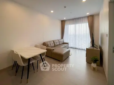 Modern living room with stylish furniture and large window offering natural light.