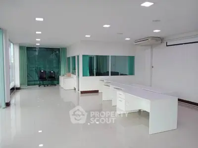 Spacious modern office space with sleek white desks and large windows