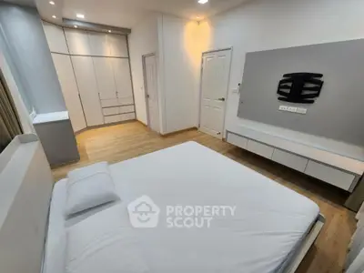 Modern bedroom with sleek design, built-in wardrobe, and minimalist decor.