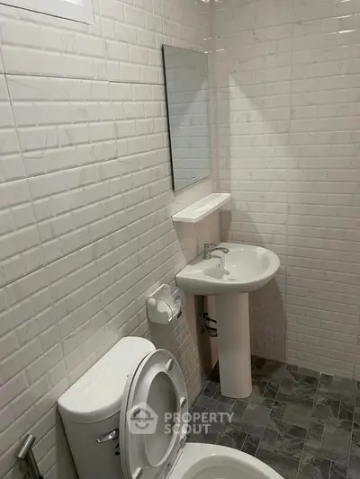 Modern bathroom with white brick tiles and sleek fixtures