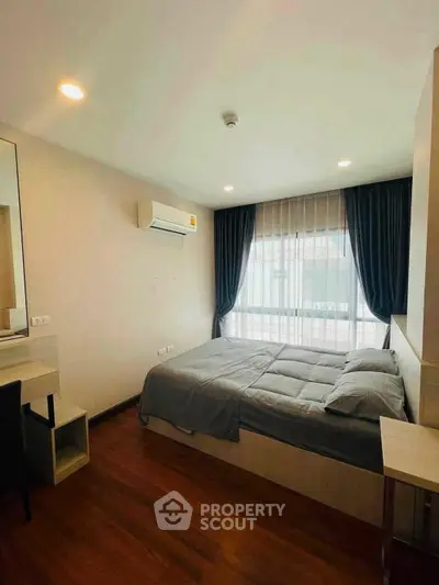 Modern bedroom with cozy bed, wooden flooring, and large window with curtains in a stylish apartment.
