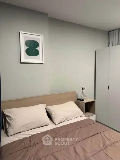 Cozy bedroom with modern decor and neutral tones, featuring a comfortable bed and stylish artwork.