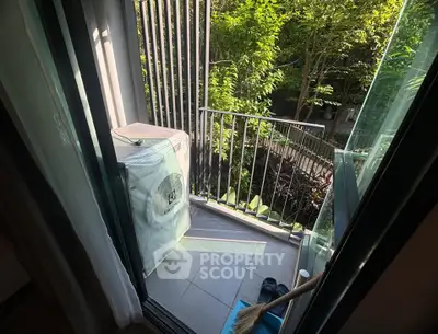 Charming small balcony with lush greenery view, perfect for relaxation and enjoying nature.