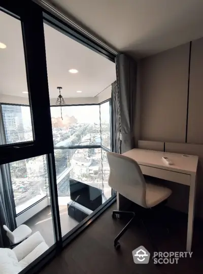 Modern study area with city view and balcony access in high-rise apartment