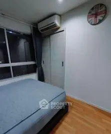 Cozy bedroom with modern air conditioning and wooden flooring, featuring a stylish wall clock.