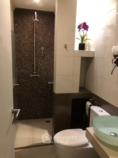 Modern bathroom with glass basin and stylish shower area