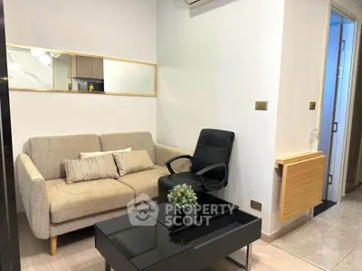 Modern living room with beige sofa, black chair, and sleek coffee table in cozy apartment.