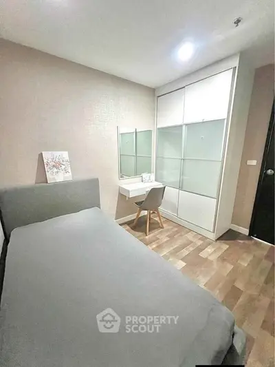 Cozy bedroom with modern decor, featuring a single bed, study desk, and spacious wardrobe.