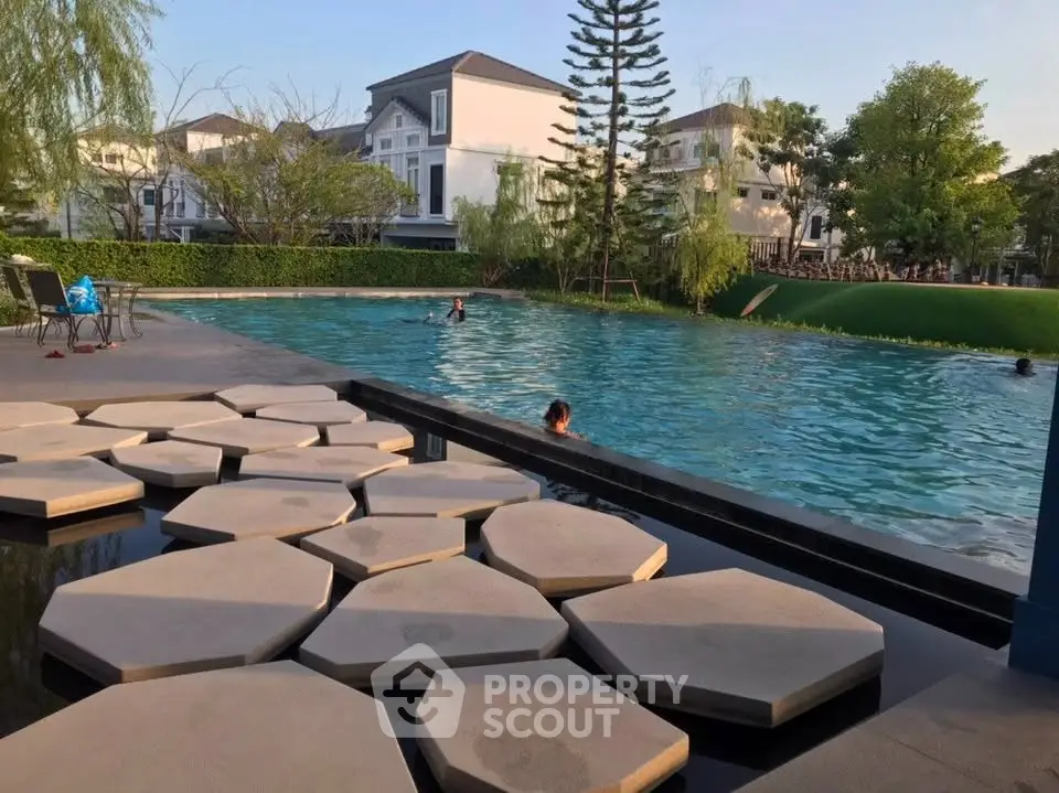 Luxurious residential pool area with modern design and lush greenery, perfect for relaxation and leisure.