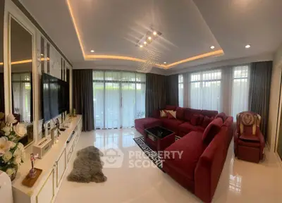 Luxurious living room with elegant red sofa and modern decor, perfect for relaxation and entertainment.