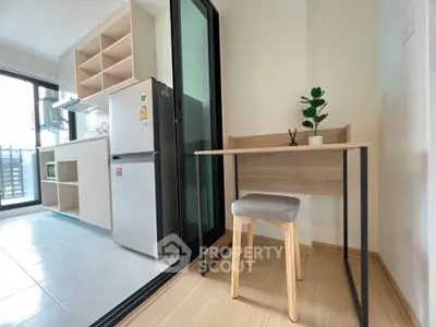 Modern compact kitchen with open layout and cozy study nook in a bright apartment.