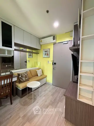 Charming modern living room with cozy seating and stylish decor in a compact apartment.