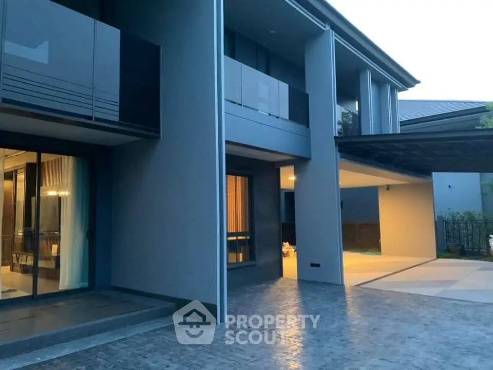 Modern two-story home with sleek design and spacious driveway at dusk.