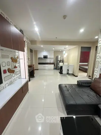 Spacious modern living room with open kitchen layout and sleek furnishings
