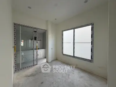 Spacious unfinished room with large window and glass door, ideal for customization.