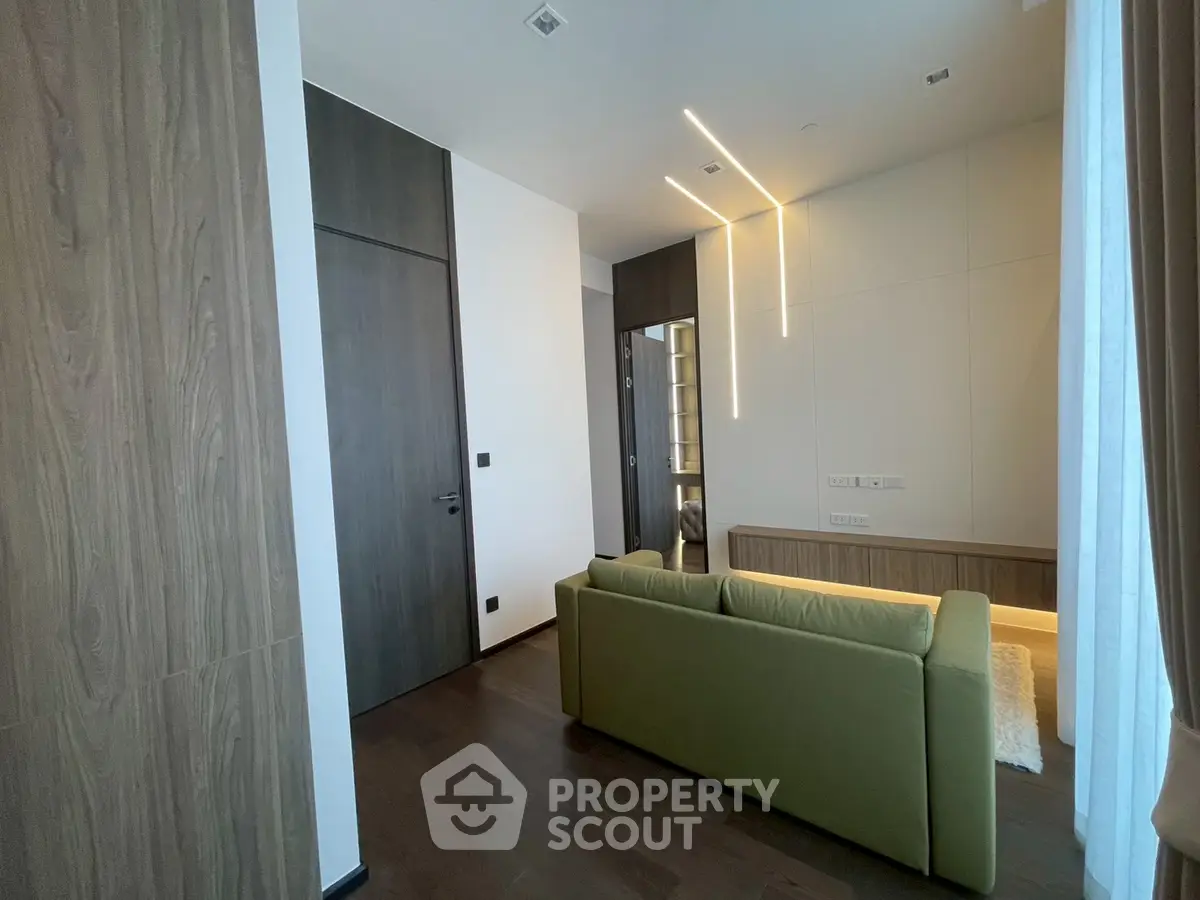 Modern living room with sleek design and green sofa, featuring wooden accents and ambient lighting.