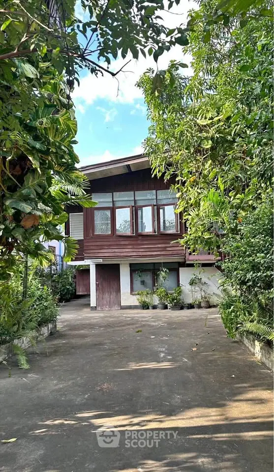 Charming wooden house surrounded by lush greenery and spacious driveway