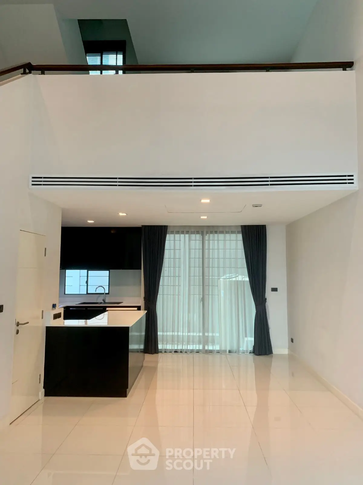 Spacious modern living area with high ceilings and sleek kitchen design