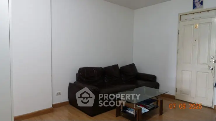 Cozy living room with brown leather sofa and glass coffee table, minimalistic design.