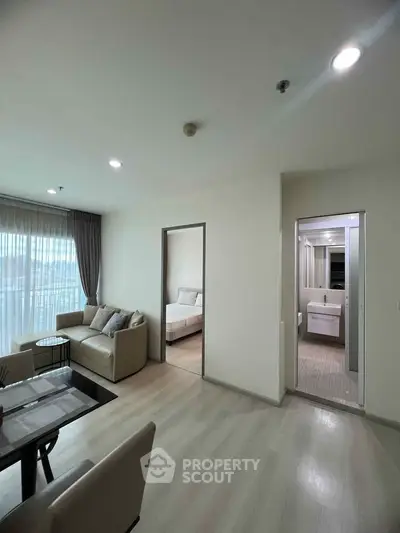 Modern apartment interior with living room, bedroom, and bathroom, featuring sleek design and natural light.