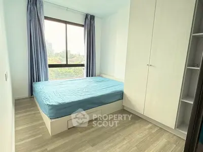 Bright bedroom with large window and modern wardrobe in a stylish apartment.