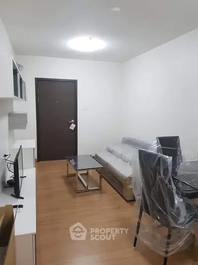 Modern living room with sleek furniture and wooden flooring in a cozy apartment.