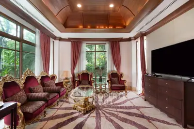 Luxurious living room with elegant furniture and large windows overlooking lush greenery.