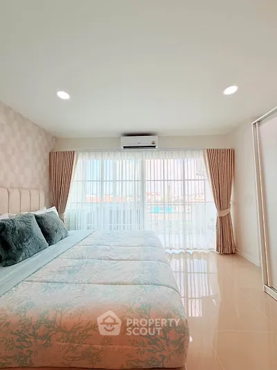Spacious bedroom with large windows and elegant decor in modern apartment