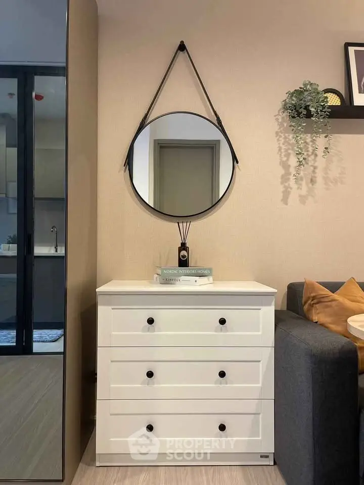 Modern living room with stylish mirror and white dresser