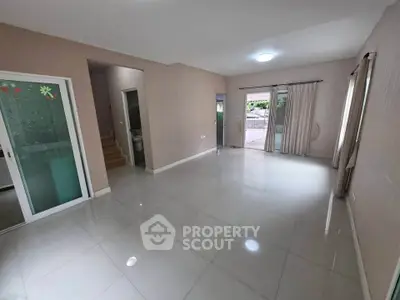 Spacious modern living room with large windows and glossy tiled floors