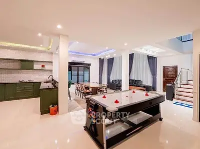 Spacious open-plan living area with modern kitchen and air hockey table