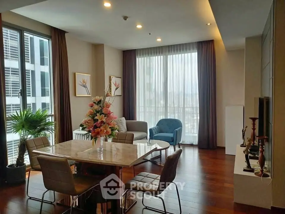Spacious living room with elegant decor and large windows offering city views.