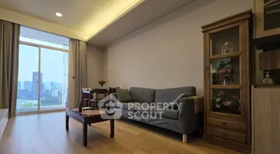 Spacious living room with city view, cozy sofa, and elegant wooden furniture.