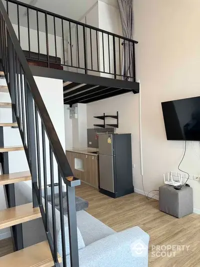 Modern loft apartment with mezzanine, open living area, and sleek kitchen design.