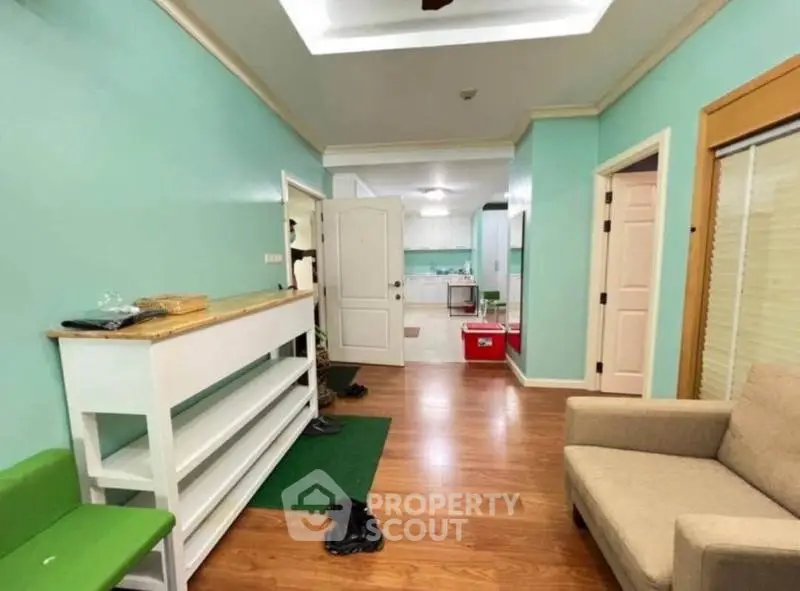 Spacious living room with modern decor and open layout, featuring hardwood floors and stylish furniture.