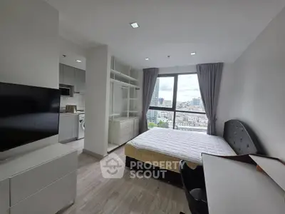 Modern bedroom with city view, featuring sleek furniture and ample natural light.